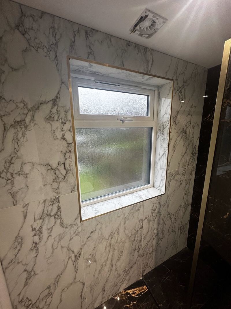Window reveal tiled in white marble-effect porcelain with mitred edges