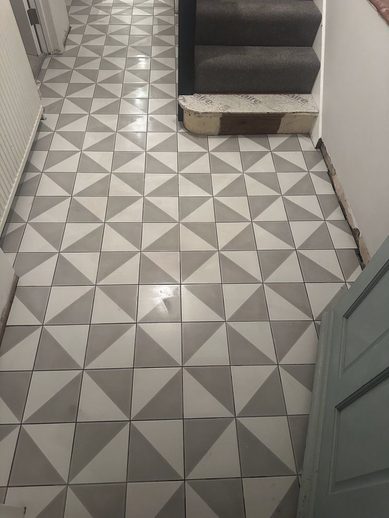 Hallway floor tiled in grey and white geometric triangle tiles